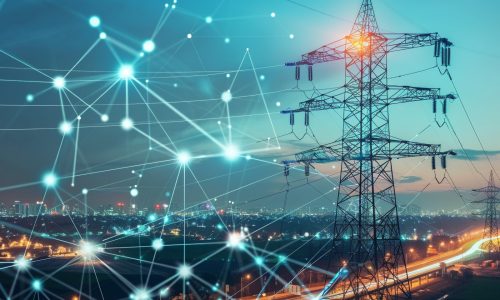High-voltage power lines and smart grid network over city at night.